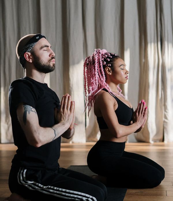 A person stretching during a yoga practice, with coral color accents.
