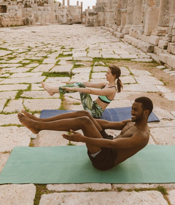 Diverse group of people smiling and preparing for a yoga session.